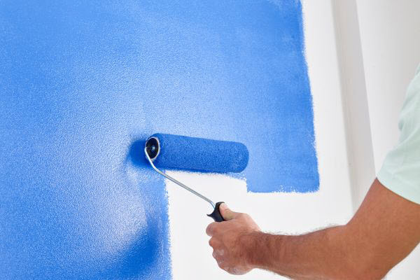 Painter Painting An Interior Wall In Blue Colour